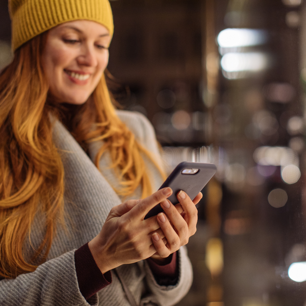 A woman dressed in winter clothes using a mobile phone during the holiday season