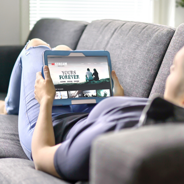 A woman streaming a movie with a tablet