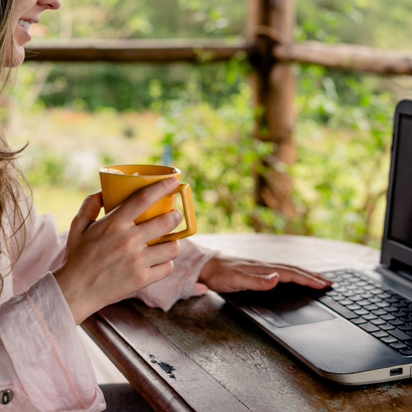 A woman holding a yellow mug trying to connect to the WiFi Internet in a campground