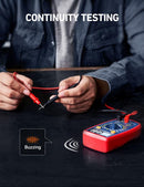 Person performing continuity testing with a AstroAI multimeter on a dark surface