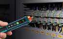 Hanmatek A hand holding a teal and black electronic testing tool with a glowing red light, pointing it toward electrical terminal blocks inside a gray industrial control panel.