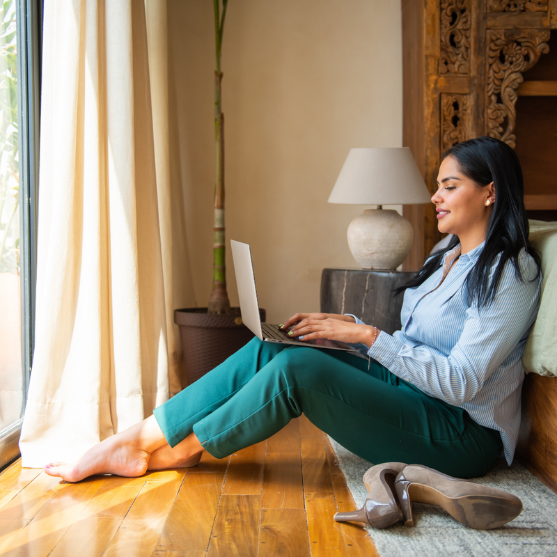 A woman working on a laptop on the floor of a boutique hotel