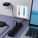 USB hub connected to a laptop with power adapter on a desk