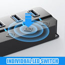 A black multi-port USB hub with individual LED indicator lights on the top surface, shown on a light gray background with a blue graphic overlay indicating individual LED switch functionality.