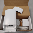 White electronic device CPE120 with accessories inside a brown cardboard box, photographed from above on a gray surface.