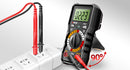 ANENG A digital multimeter with a black and gray body, standing on its side to support itself. Red and black test leads are connected to its COM and VCC terminals, with one lead also plugged into a white power strip.